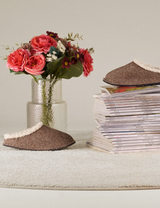 Hüttenschuhe aus Filz im gemütlichen Wohnambiente mit Blumen und Magazinen
